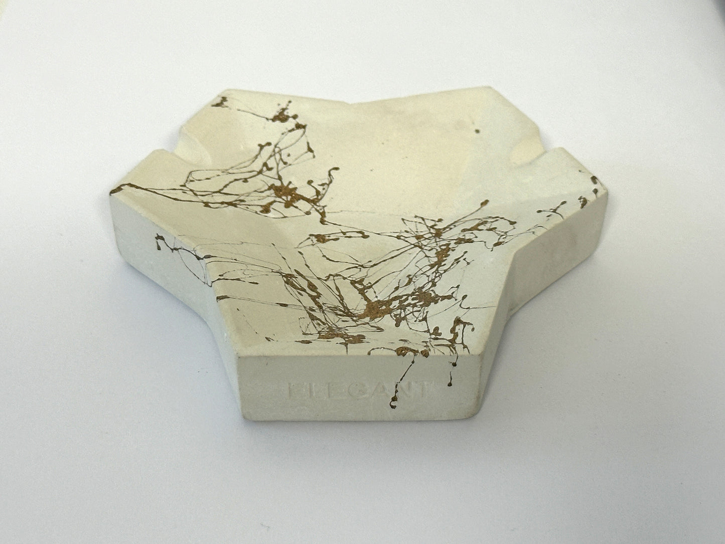 Aschenbecher 6-ECK weiß, Marmorierung gold, Betonmischung, bruchsicher und solide Formgebung, weiß, jeder Aschenbecher ist ein Unikat! Während der handgemachten Gestaltung kann der Grundfarbton und Struktur abhängig vom Mischverhältnis von dem im Foto abgebildeten Aschenbecher gering abweichen. Das Gewicht variiert um zwischen 150-175 gr. Größe (gemessen am Umkarton der Verpackung): L/B/H 10,2 cm X 10,2 cm X 3,7 cm Katalogpreis=12,95 Aktionspreis zur Eröffnung unseres EDELEGANT - Shops = nur 8,95